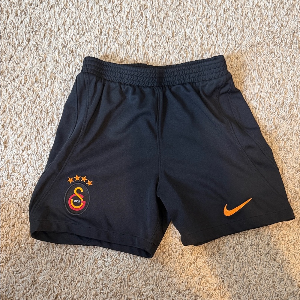 Nike Kids Black Shorts with Orange Swoosh and Red/Yellow Crest